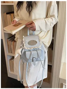 Detail of a stylish retro light blue mini backpack with lace and metal plaque