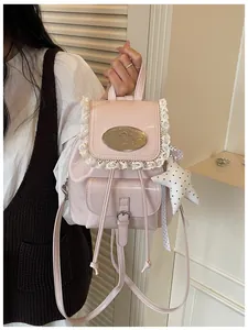 Close-up of pink mini backpack featuring delicate lace trim and star-shaped charm.