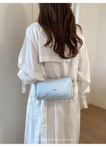 Rückansicht einer minimalistischen hellblauen Boston-Tasche, getragen von einem Modell