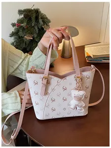 Exquisite pink monogram crossbody bucket bag held by hand in a lifestyle setting
