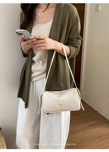 Elegante cremeweiße Kissentasche für Damen, präsentiert als schickes Schulteraccessoire.