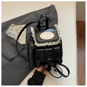 Chic vintage black mini backpack featuring white lace trim and metallic logo plate.