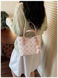 Elegant pink handbag with reindeer print and cute bear charm for daily commute