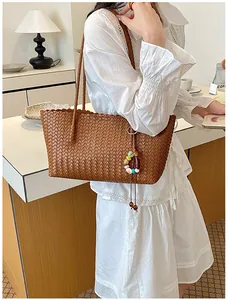 Sac cabas tissé marron avec breloque colorée dans une scène de vie
