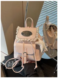 Close-up detail of a pink mini retro backpack featuring lace trim and a star charm accessory