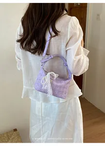 Back view of a trendy lavender plaid dumpling bag with lace and pearl bow details.