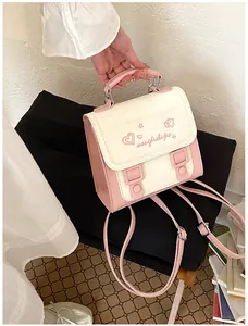 Detailed close-up of the stylish pink and white backpack featuring embroidered heart patterns.