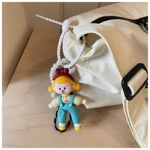 Close-up detail of a cream canvas bag featuring a cute doll charm and textured fabric