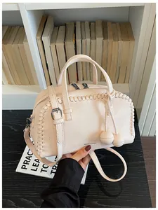 Detailed view of pink Boston pillow bag with pebble leather and woven stitch accents.