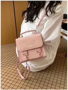 Close-up detail of a cute pink satchel backpack for women in a white dress outfit