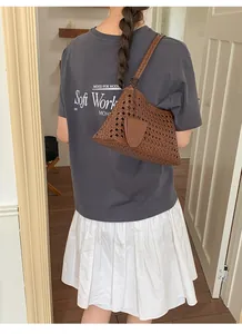 Sac seau en tissage creux marron porté à l'épaule pour un look d'été décontracté chic