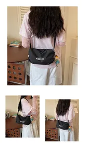 Detailed view of a casual black checkered canvas crossbody bag worn by a model in a room