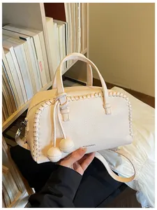 Close-up detail of cream grainy leather Boston bag with unique woven edge design