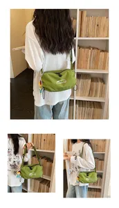 Detailed view of green grid canvas crossbody bag worn by a model in casual setting.