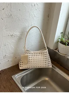 Détails de la texture tissée ajourée et de la structure du sac à bandoulière crème