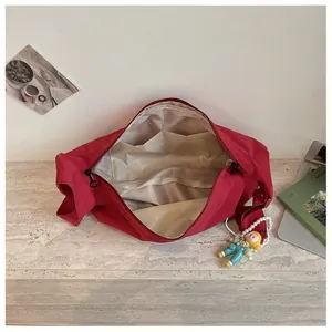 Interieur detail van rode nylon draagtas met opbergvakken en voering zichtbaar