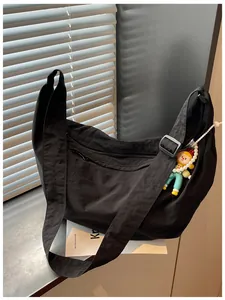 Detailopname van een casual zwarte nylon crossbodytas met een verstelbare schouderriem