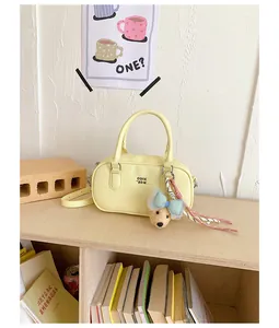 Detailed shot of a yellow bowling handbag with a cute dog charm on a wooden shelf