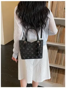 Close-up view of a woman wearing a stylish black patterned commuter tote bag in a library.