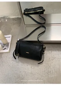 Detailansicht einer schwarzen Retro-Boston-Tasche mit goldenen Beschlägen im Minimal-Stil