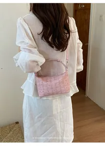 Back view of a woman wearing a chic pink tweed shoulder bag with silver studs.