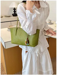 Femme portant un sac cabas tressé vert avec un accessoire de perles colorées