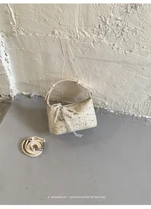 Vintage beige checkered handbag with lace bow detail and adjustable shoulder strap