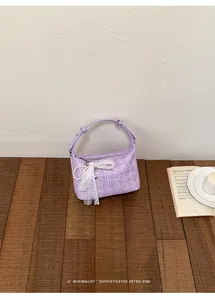 Purple plaid tweed handbag featuring lace bow charm in a minimalist retro setting