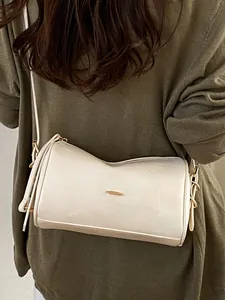 Elegante cremeweiße Boston-Tasche für Damen als Umhängetasche zu olivgrünem Strickpullover