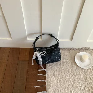 Detailed shot of dark plaid dumpling handbag with elegant pearl and lace bow charm