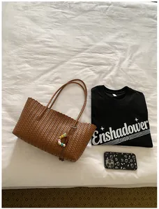 Grand sac cabas tressé marron présenté dans un décor de chambre chic