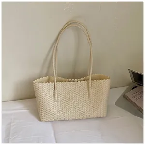 Sac cabas tressé crème avec bord festonné décoratif et longues poignées élégantes.
