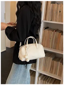 Chic white Boston handbag with braided detail and spherical charms