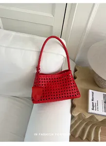 Vue détaillée de la texture tressée rouge ajourée de ce sac à main d'été.