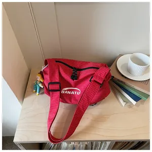 Red checkered canvas crossbody shoulder bag featuring white BANATU logo and cute doll charm.