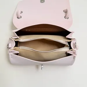 Innenansicht der kleinen rosa Umhängetasche mit mehreren Fächern und silbernen Reißverschlüssen