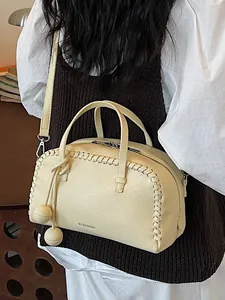Cream yellow Boston handbag for women with woven edge details and crossbody strap.