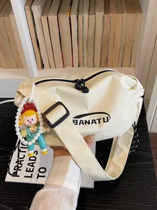 Trendy beige nylon crossbody bag with cute charm and BANATU logo for daily commuting