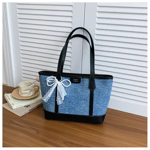 Large denim tote bag with black trim and elegant lace pearl bow decoration for women