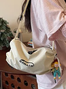 Casual cream canvas shoulder bag with BANATU logo and cute doll charm for stylish women