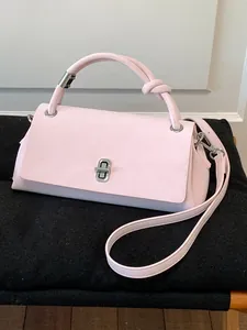 Elegante hellrosa Handtasche mit modischem Knotengriff und silbernem Drehverschluss