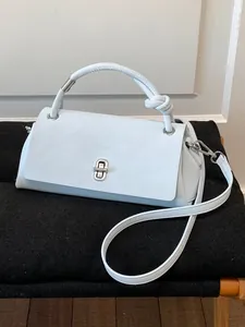 Minimalistische hellblaue Umhängetasche aus Leder mit einzigartigem Knotengriff