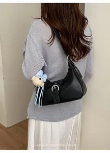 Vista trasera de un bolso hobo retro negro combinado con un suéter gris elegante