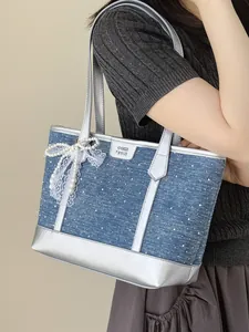 Chic large blue denim tote bag with silver trim and elegant pearl bow accessory for women