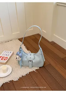 Sofisticado bolso de hombro hobo azul claro con un lindo detalle de colgante de oso