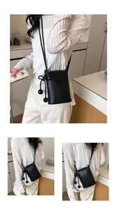 Detailansicht einer eleganten schwarzen Umhängetasche aus geprägtem Leder für Handys.