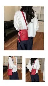 Detaillierte Ansichten einer exquisiten roten Mini-Beuteltasche für Damen am Modell