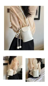 Detailansichten einer weißen Crossbody-Handytasche mit Kugelanhängern und Krokostruktur.