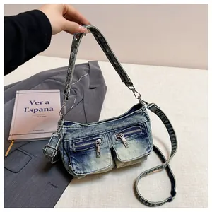 Detailed view of a vintage washed denim shoulder bag featuring double front zipper pockets