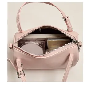 Detailed interior view of pink cylinder bag showing storage for makeup and accessories